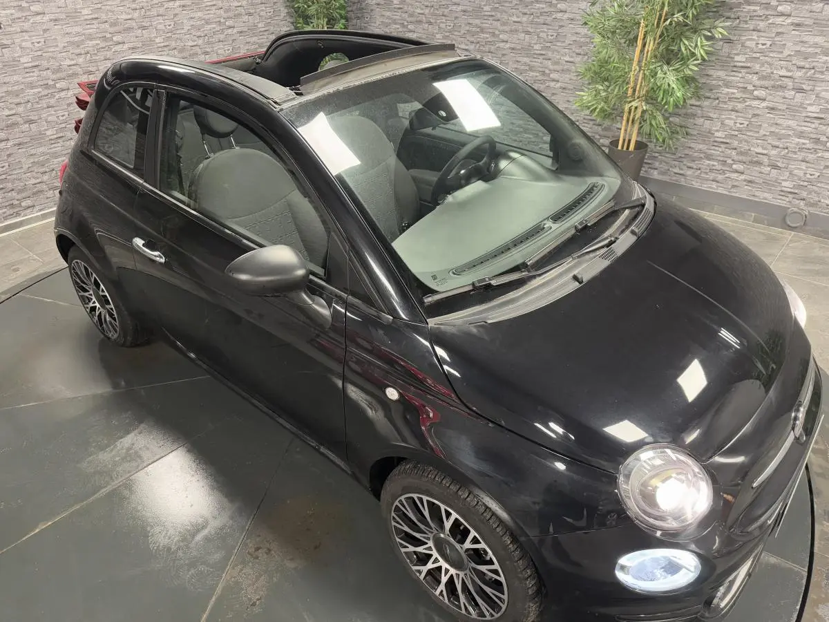 Fiat 500 Cabriolet noire vue 3/4 avant droit avec capote ouverte et jantes alliage 16 pouces Spider.