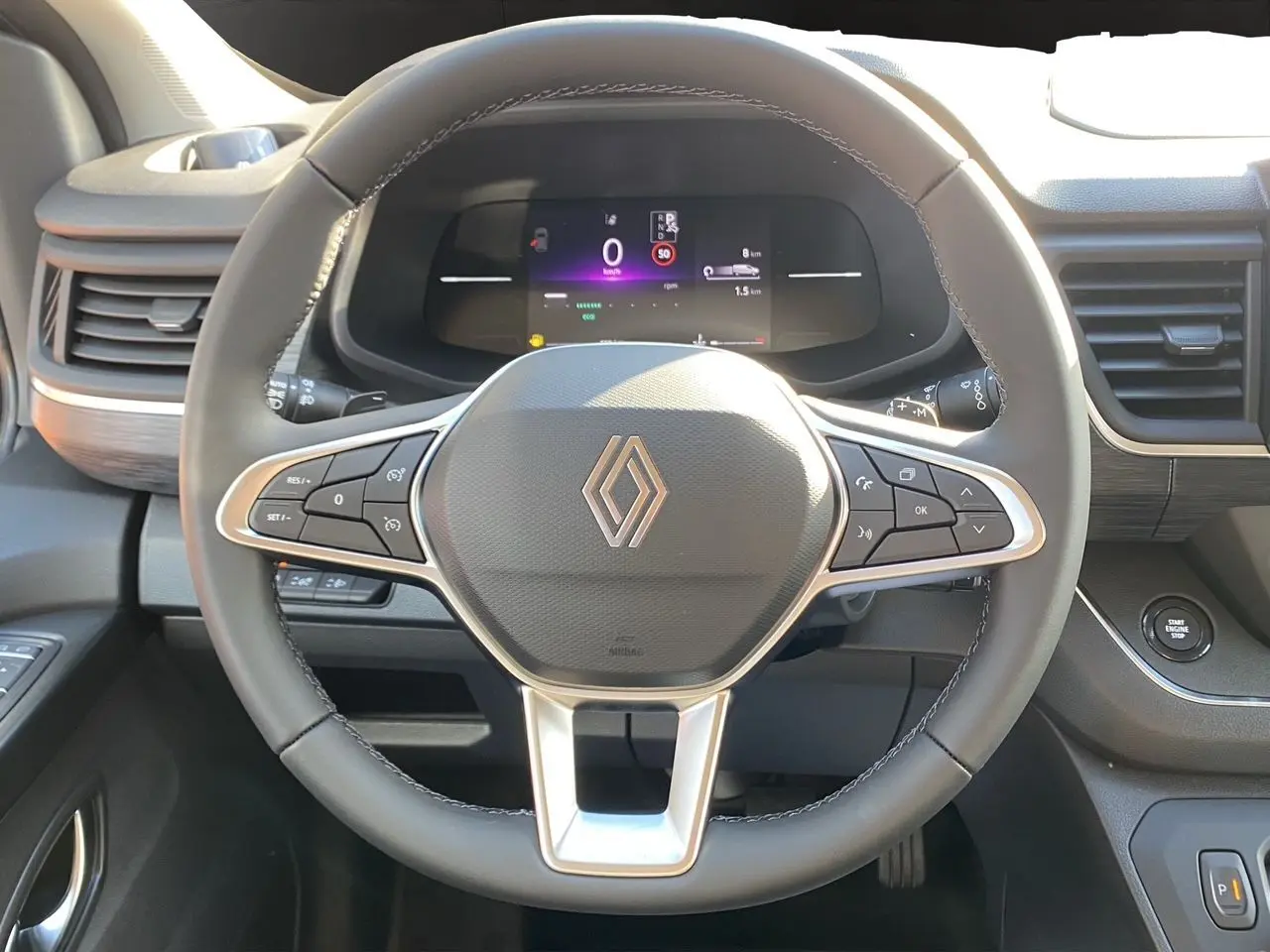 Vue rapprochée du volant noir et du tableau de bord digital du Renault Trafic Combi 2025 avec commandes intégrées.