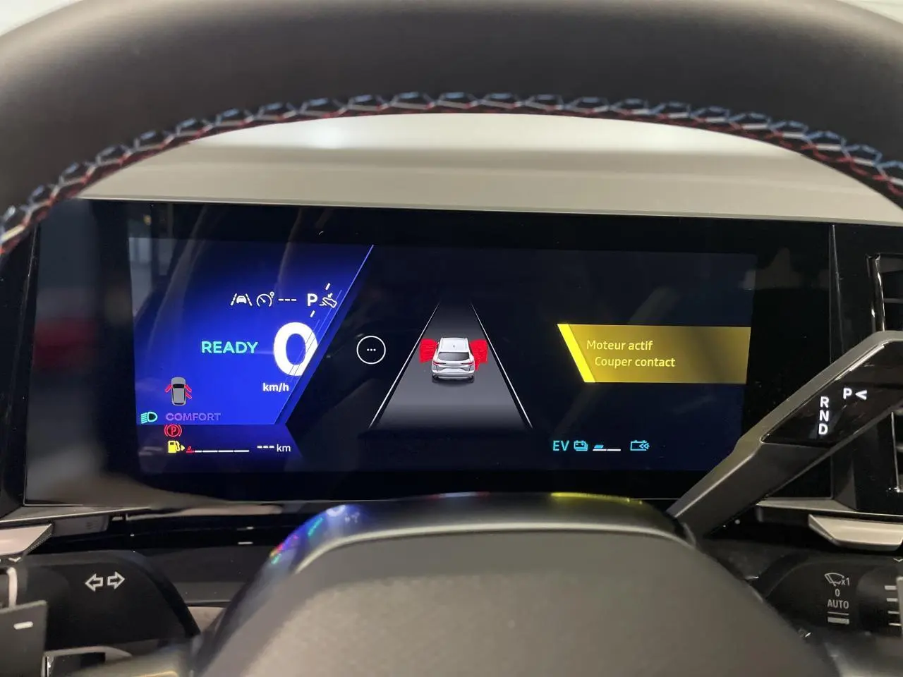 Tableau de bord numérique du Renault Austral 2025 en mode confort avec affichage d’alerte moteur actif.