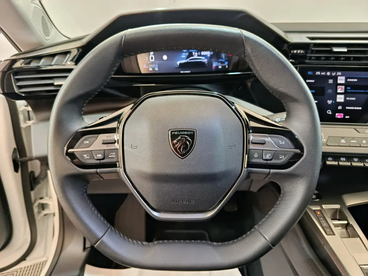 Vue rapprochée du volant cuir noir de la Peugeot 308 2022 avec affichage digital et commandes multifonctions.