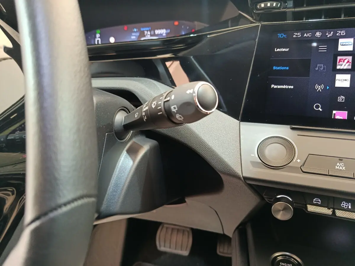 Vue intérieure rapprochée du tableau de bord et volant noir de la Peugeot 308 2022 avec écran tactile et commandes digitales.