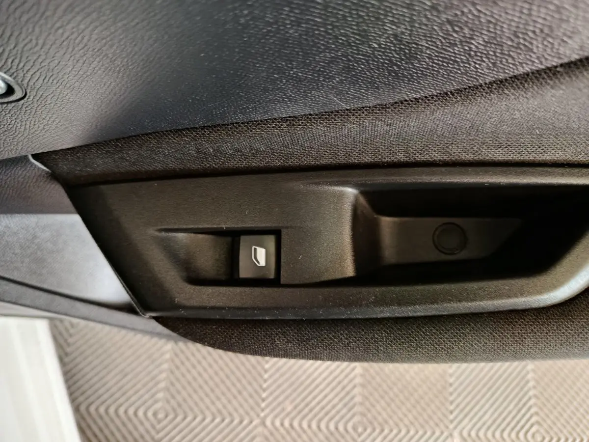 Gros plan sur le bouton de commande de ventilation additionnelle côté passager dans une Peugeot 308 blanche.