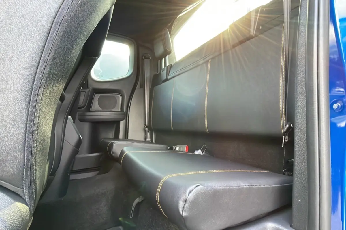 Vue intérieure arrière côté droit du Ford Ranger 2.0 205 Wildtrak Supercab bleu lightning, banquette en cuir noir avec surpiqûres jaunes.