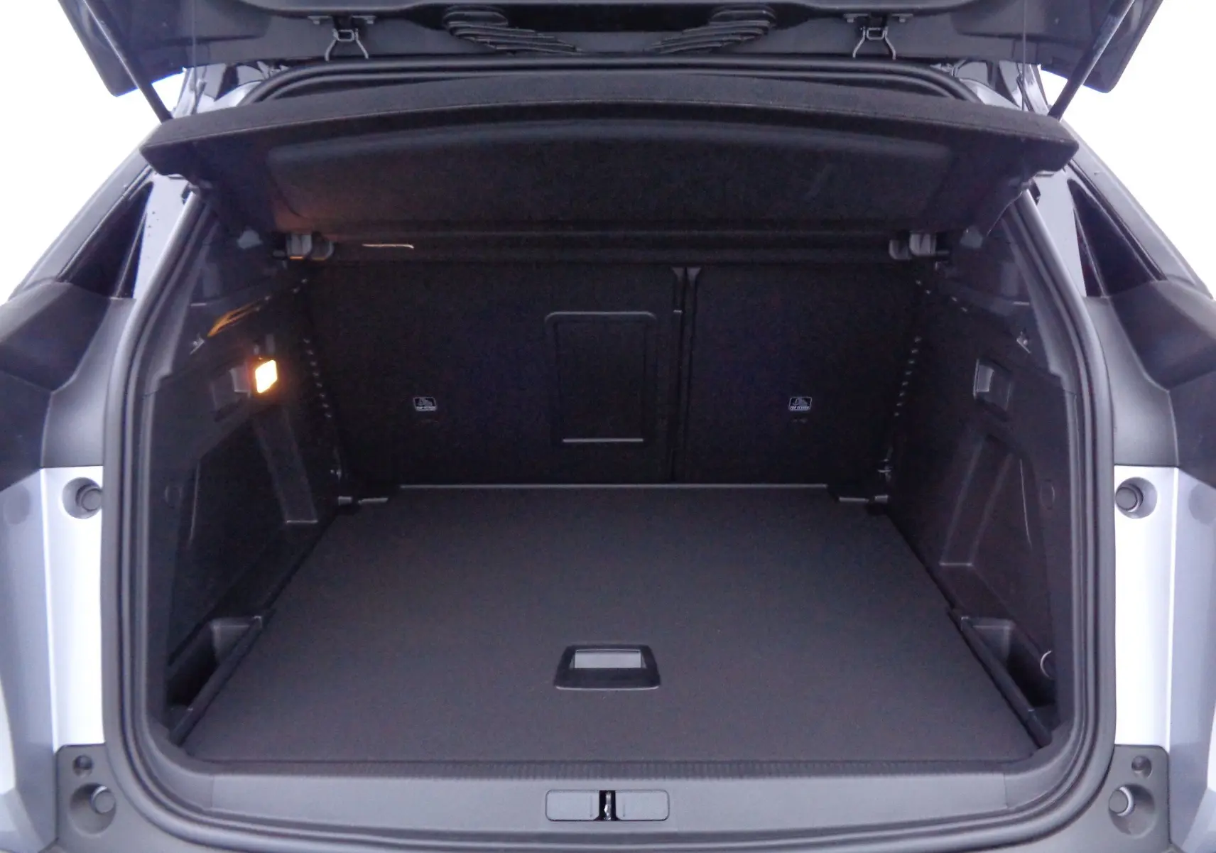 Coffre ouvert du Peugeot 3008 gris Artense Metal, vue arrière montrant un espace de chargement spacieux et bien éclairé.