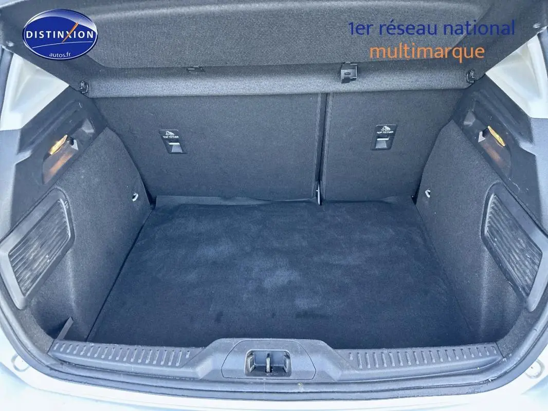 Coffre ouvert d'une Ford Focus gris clair 2019, vue arrière mettant en valeur l'espace de chargement propre et tapissé.