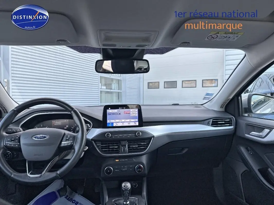 Intérieur avant de la Ford Focus gris clair 2019, tableau de bord avec écran tactile et volant multifonction.