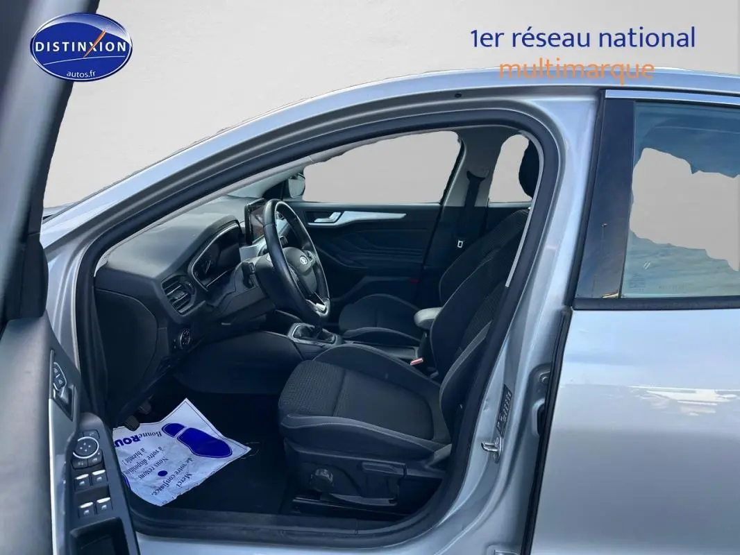 Vue côté gauche intérieur d'une Ford Focus gris clair 2019, montrant sièges avant et tableau de bord moderne.