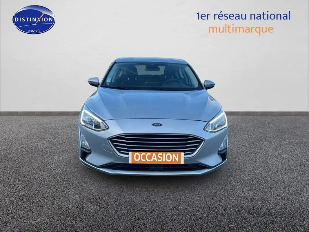 Vue frontale d'une Ford Focus gris clair 2019 avec calandre large et feux LED allumés sur fond neutre.