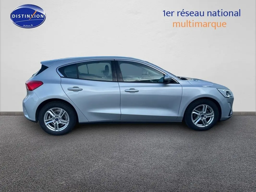 Profil côté gauche d'une Ford Focus gris clair 2019 avec jantes alliage 16 pouces sur fond neutre.