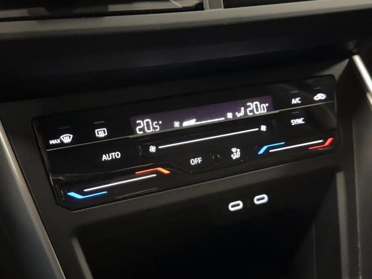 Gros plan sur la commande de climatisation digitale du Volkswagen Taigo gris, avec affichage température et deux ports USB-C.