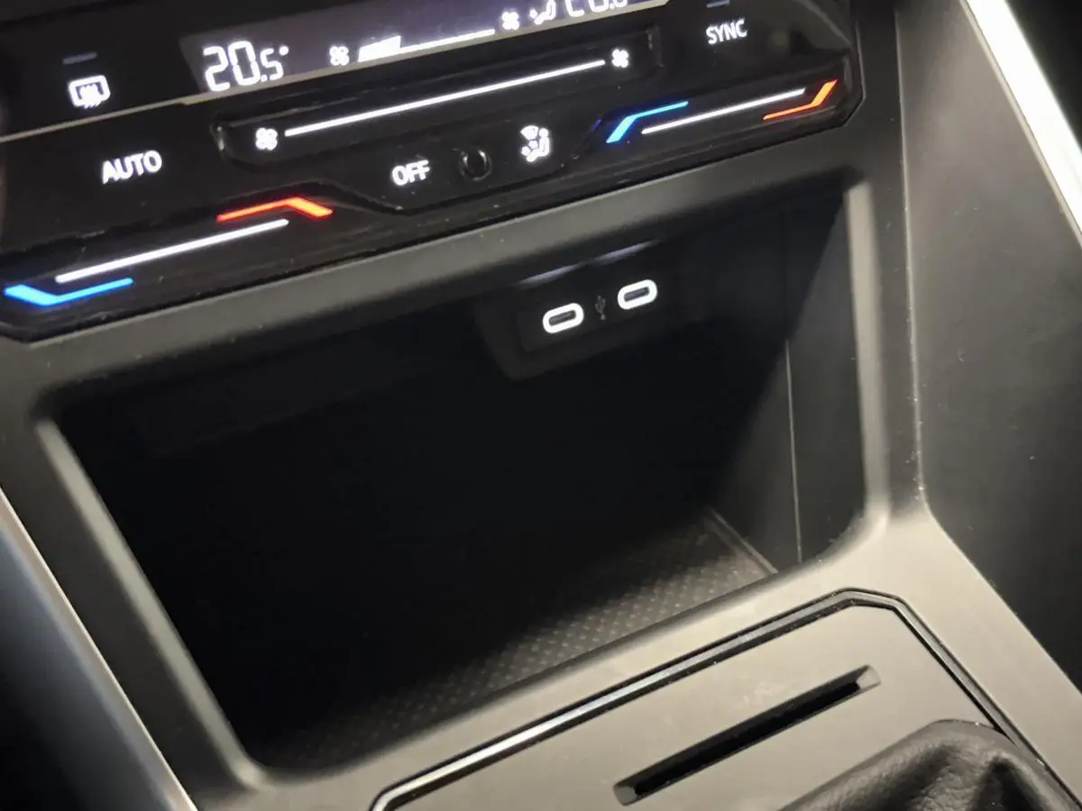 Vue rapprochée de la console centrale noire du Volkswagen Taigo 2024 avec deux ports USB-C et commandes de climatisation.
