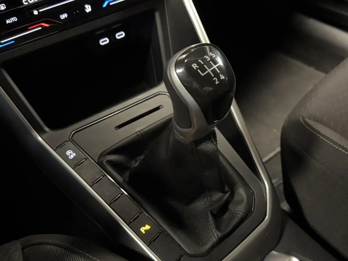 Le levier de vitesses manuel noir du Volkswagen Taigo 1.0 TSI 95 Life vu en gros plan côté droit intérieur.