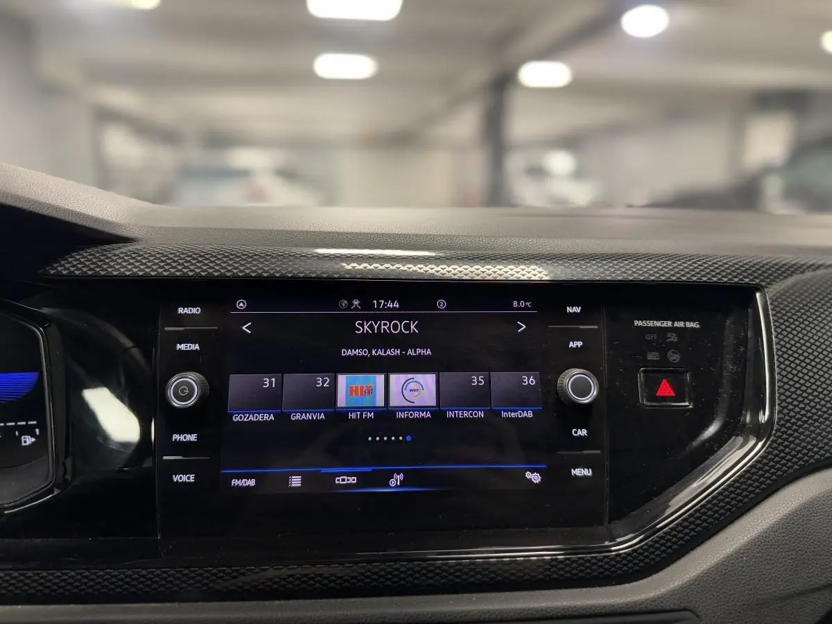 Écran tactile central 8 pouces du Volkswagen Taigo gris 2024, affichant la radio Skyrock dans l'habitacle.