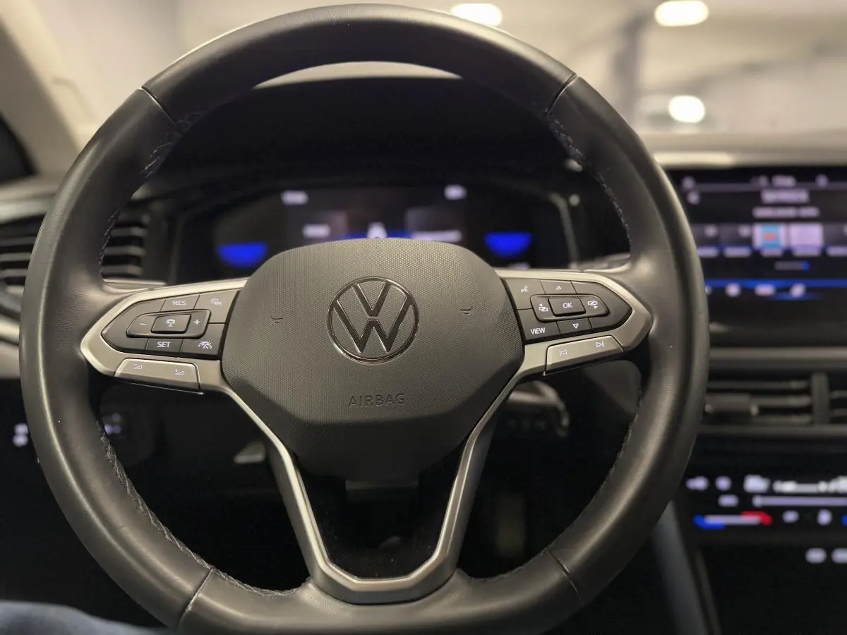 Volant cuir multifonctions Volkswagen Taigo 2024 vu de face avec tableau de bord numérique et écran tactile.