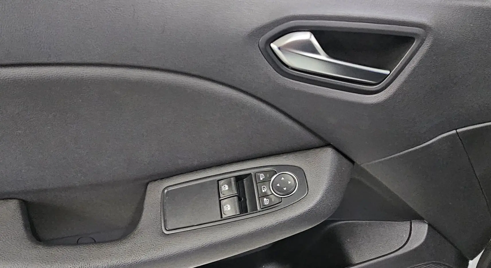 Détail de la porte côté conducteur de la Renault Clio 2020 avec commandes de vitres et rétroviseurs noirs.