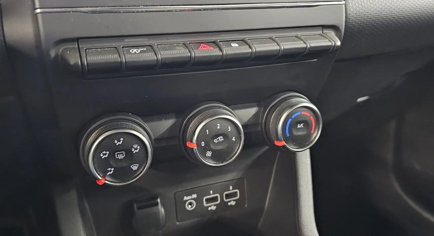Gros plan sur les commandes de climatisation et connectiques USB de la Renault Clio blanche Glacier 2020.