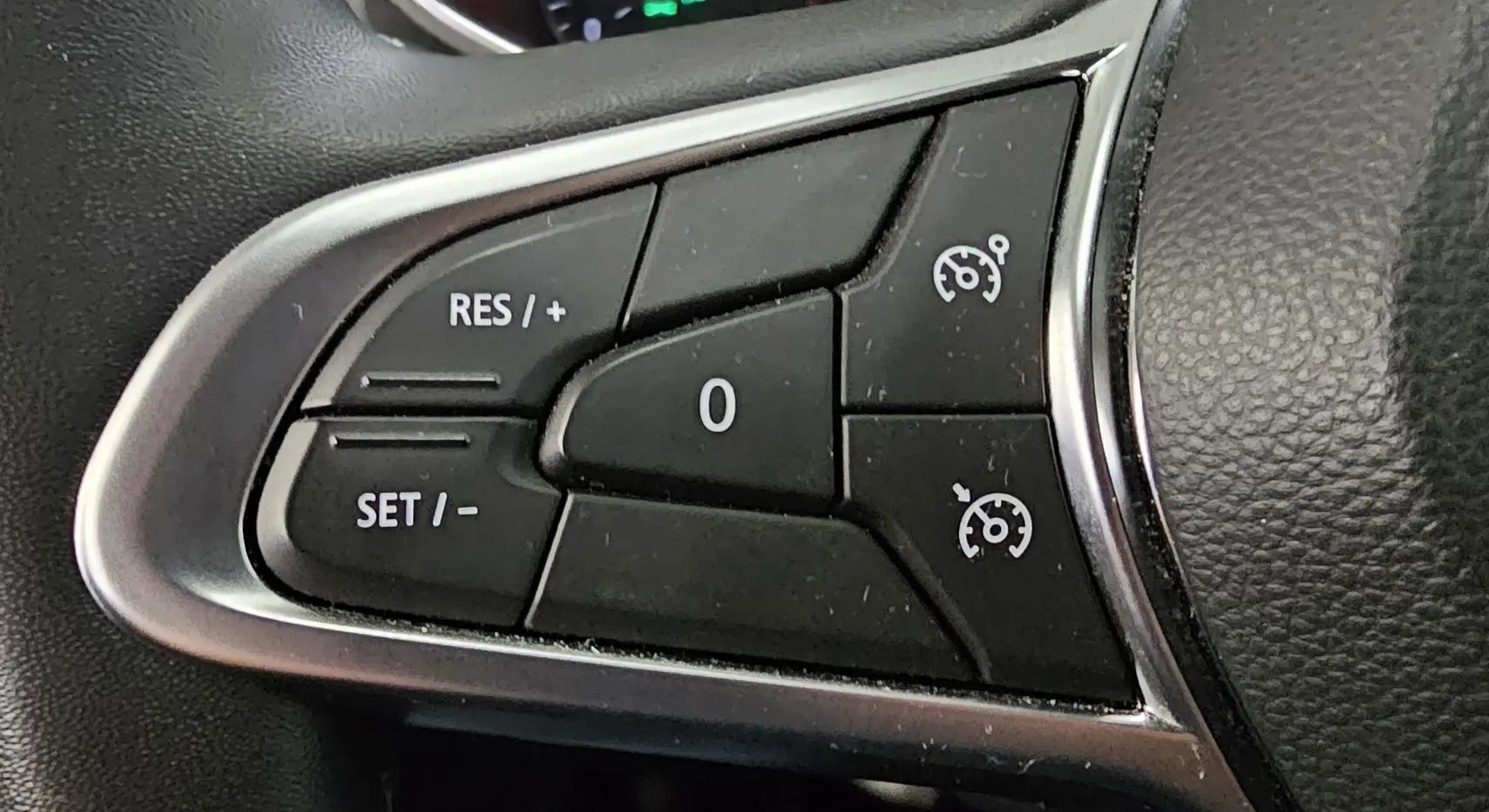 Gros plan sur les commandes de régulateur de vitesse au volant d'une Renault Clio blanche Glacier de 2020.