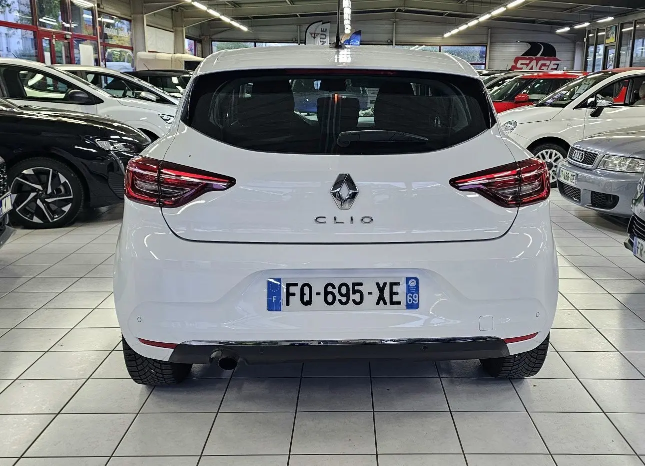 Vue arrière d'une Renault Clio blanche glacier 2020 avec feux LED et plaque d'immatriculation française visible.