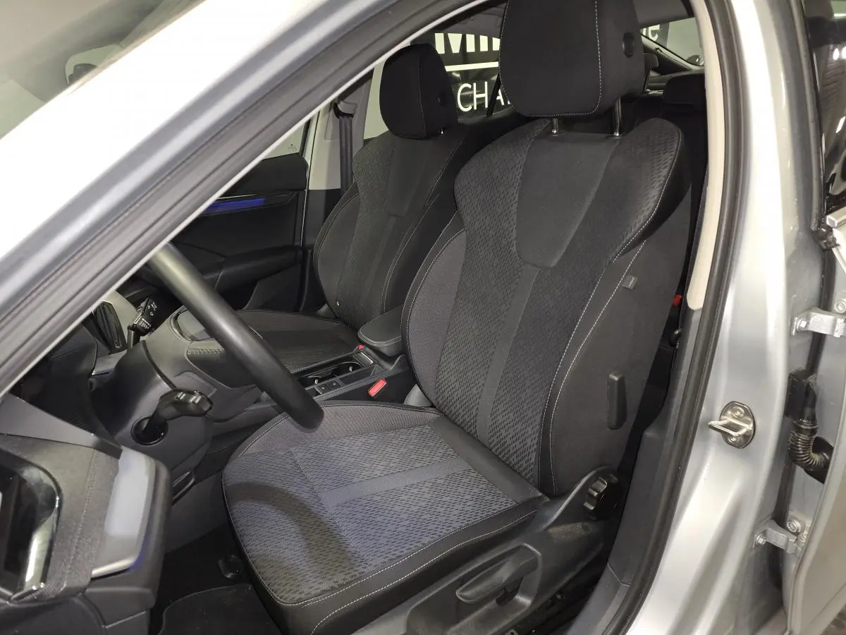 Intérieur avant droit d'une Skoda Octavia 2023 gris, sièges tissu noir avec console centrale visible.