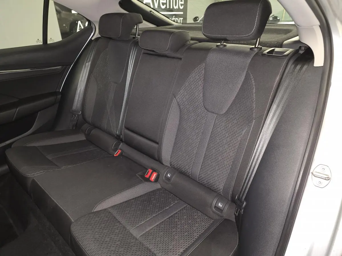 Vue intérieure sur la banquette arrière noire en tissu de la Skoda Octavia 2023, avec appuie-têtes et ceintures visibles.
