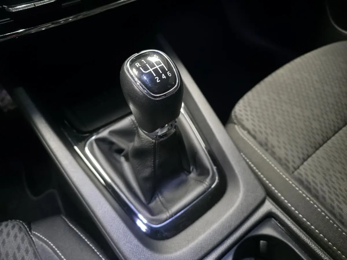 Le levier de vitesses manuel noir de la Skoda Octavia 2023, avec sellerie tissu grise visible en gros plan intérieur.