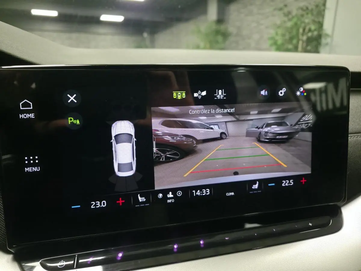 Écran central de la Skoda Octavia 2023 montrant la caméra de recul et l'aide au stationnement en intérieur.