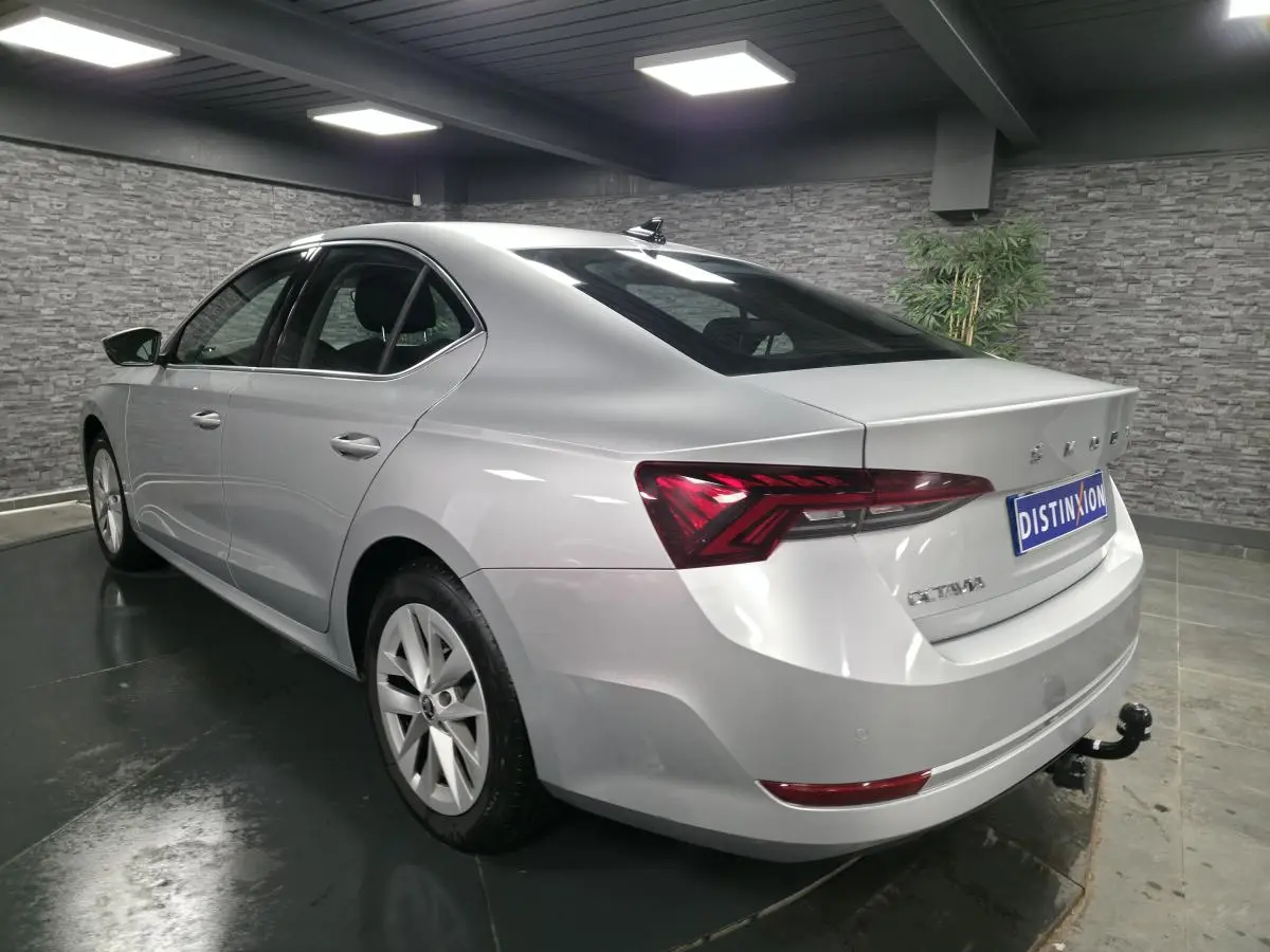 Vue 3/4 arrière droite d'une Skoda Octavia gris métallisé 2023 avec attelage fixe et jantes alliage 17 pouces.