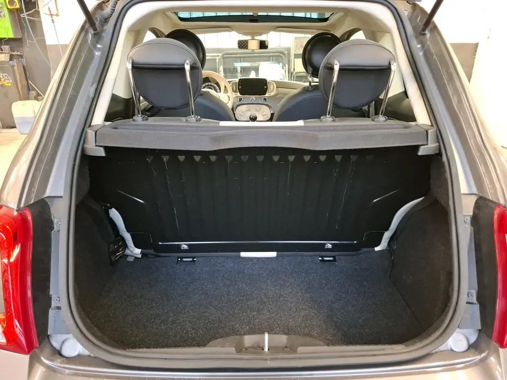Vue arrière du coffre ouvert d'une FIAT 500 Gris Electroclash 2022, avec intérieur noir et planche de séparation visible.