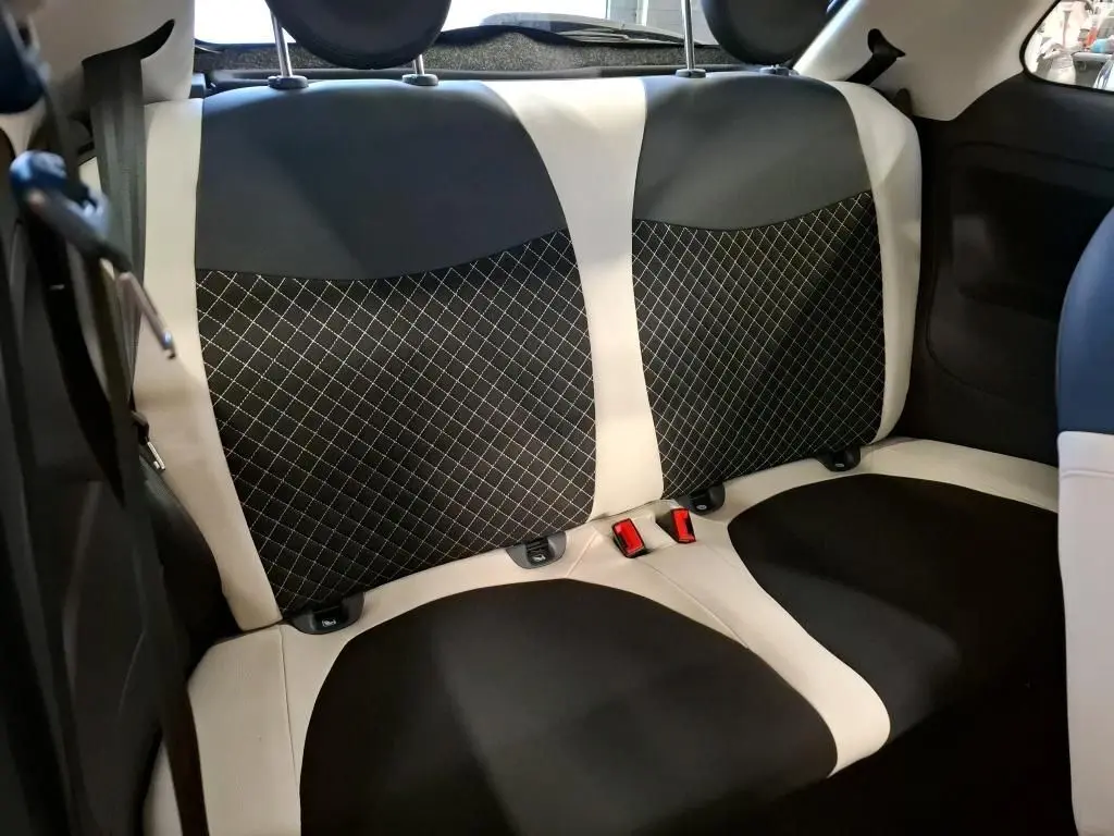 Vue rapprochée des sièges arrière bicolores noir et blanc de la Fiat 500 Dolcevita 2022, avec surpiqûres croisées.