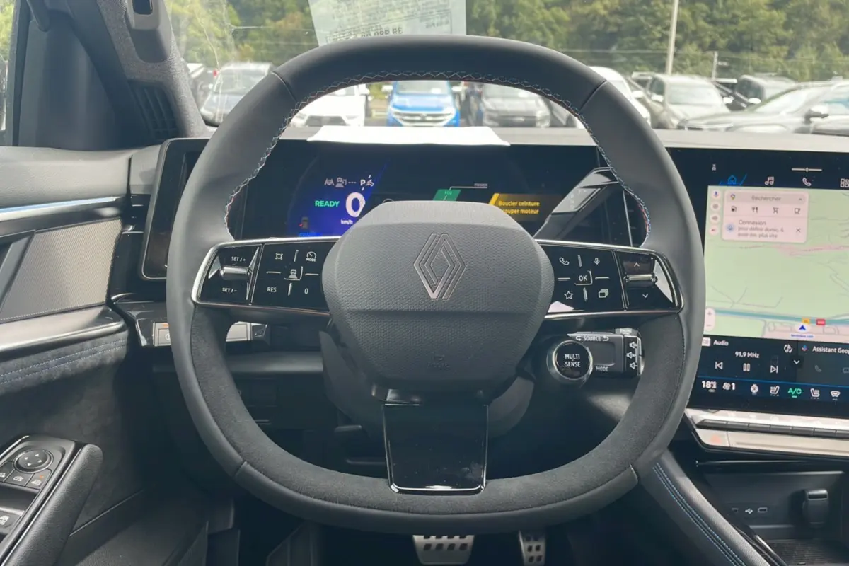 Vue intérieure centrée sur le volant noir en alcantara du Renault Austral New 200 Esprit Alpine avec tableau de bord numérique.