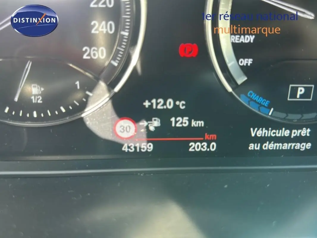 Tableau de bord numérique de BMW X1 F48 LCI, affichant la température extérieure à 12°C et l'autonomie à 125 km.