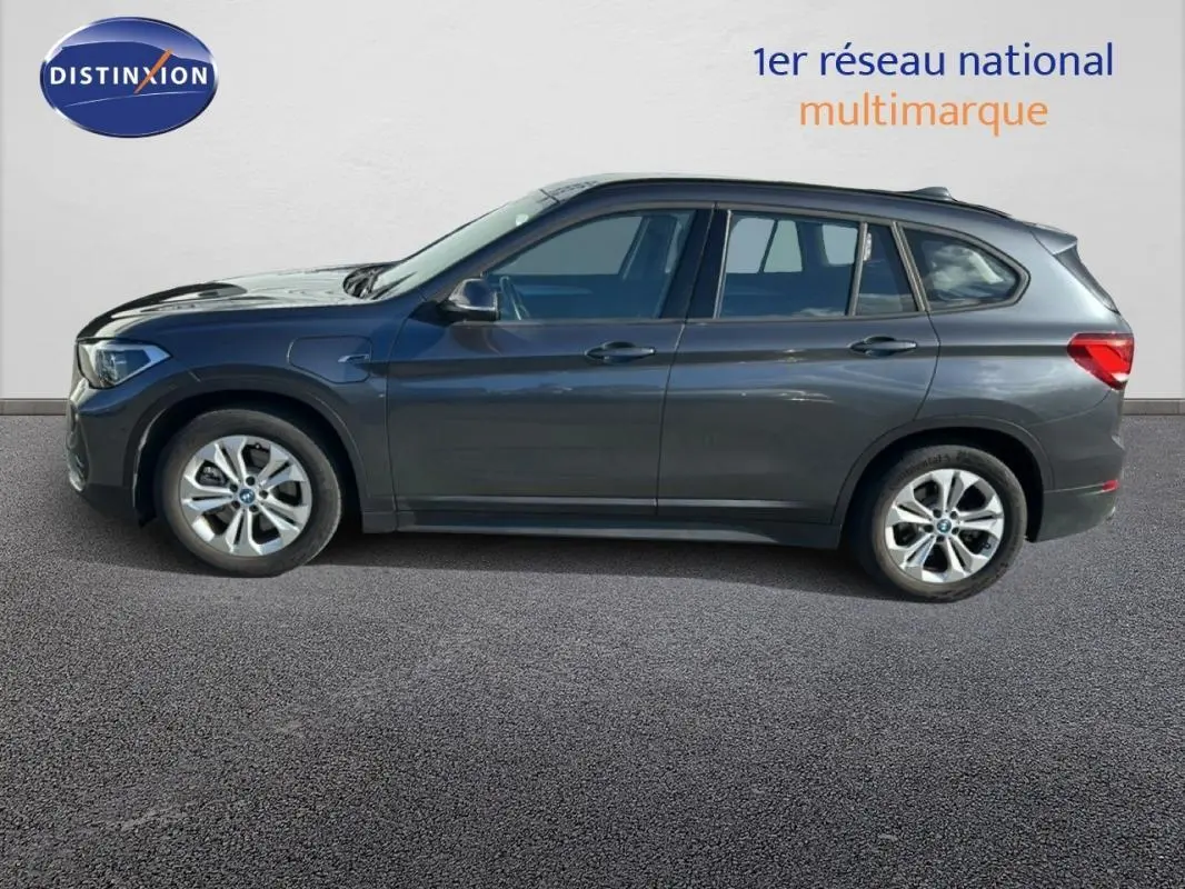 Profil côté gauche d'un BMW X1 gris foncé 2022 avec jantes alliage 18 pouces sur fond neutre.