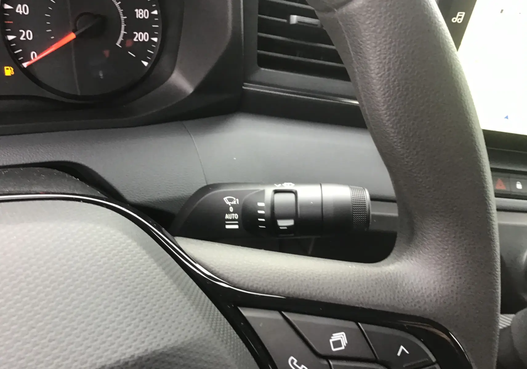 Gros plan sur le volant et la manette d’essuie-glace du Renault Master blanc, mettant en valeur les commandes intégrées au volant.