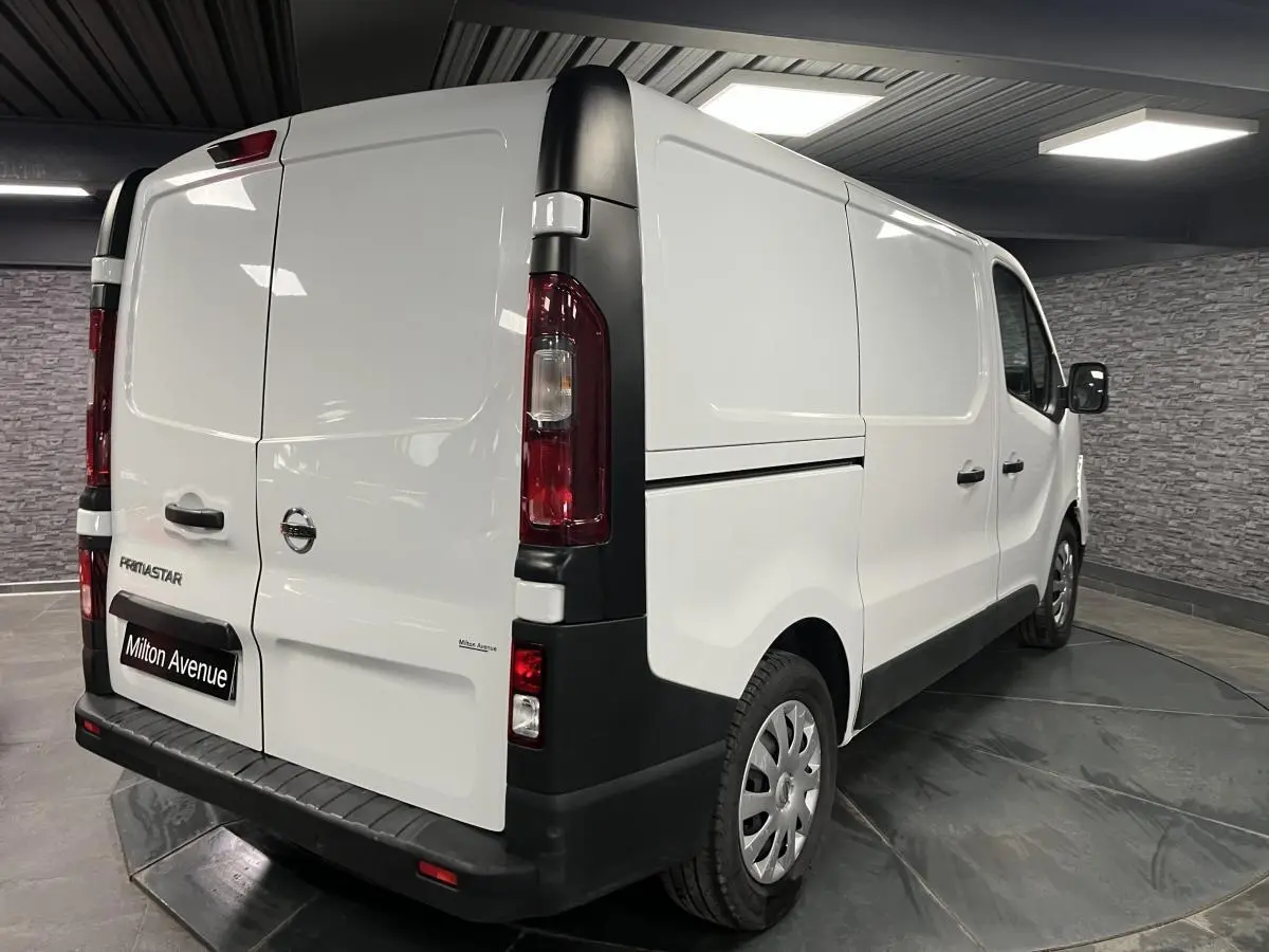 Vue 3/4 arrière droite d'un utilitaire Nissan Primastar blanc avec portes arrière tôlées et jantes acier 16 pouces.