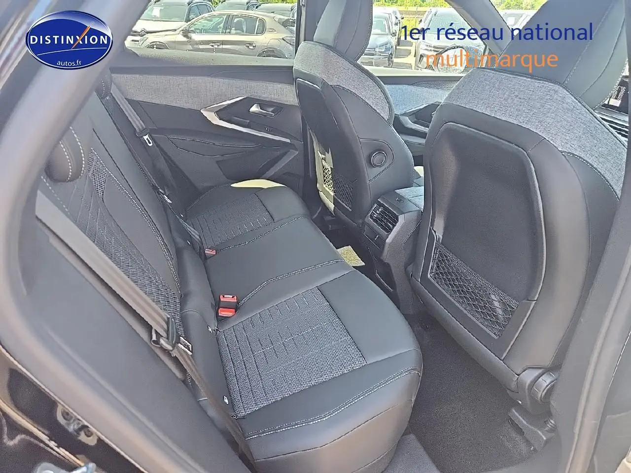 Vue intérieure arrière montrant la banquette en tissu gris et cuir noir du Peugeot 3008 hybride 2025.