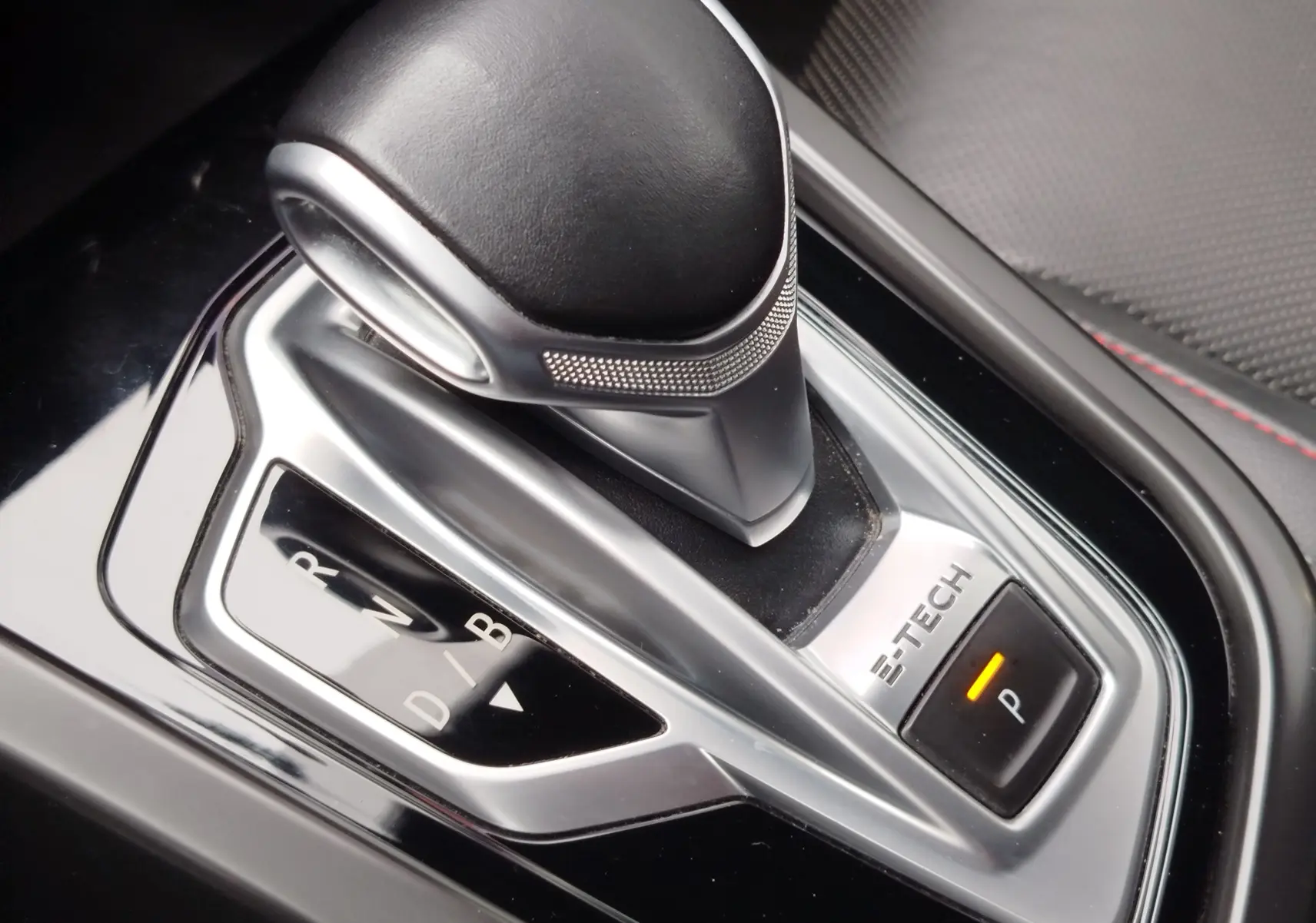 Gros plan sur le levier de vitesses automatique E-Tech de la Renault Arkana 1.6 hybride, finition RS Line, intérieur noir.
