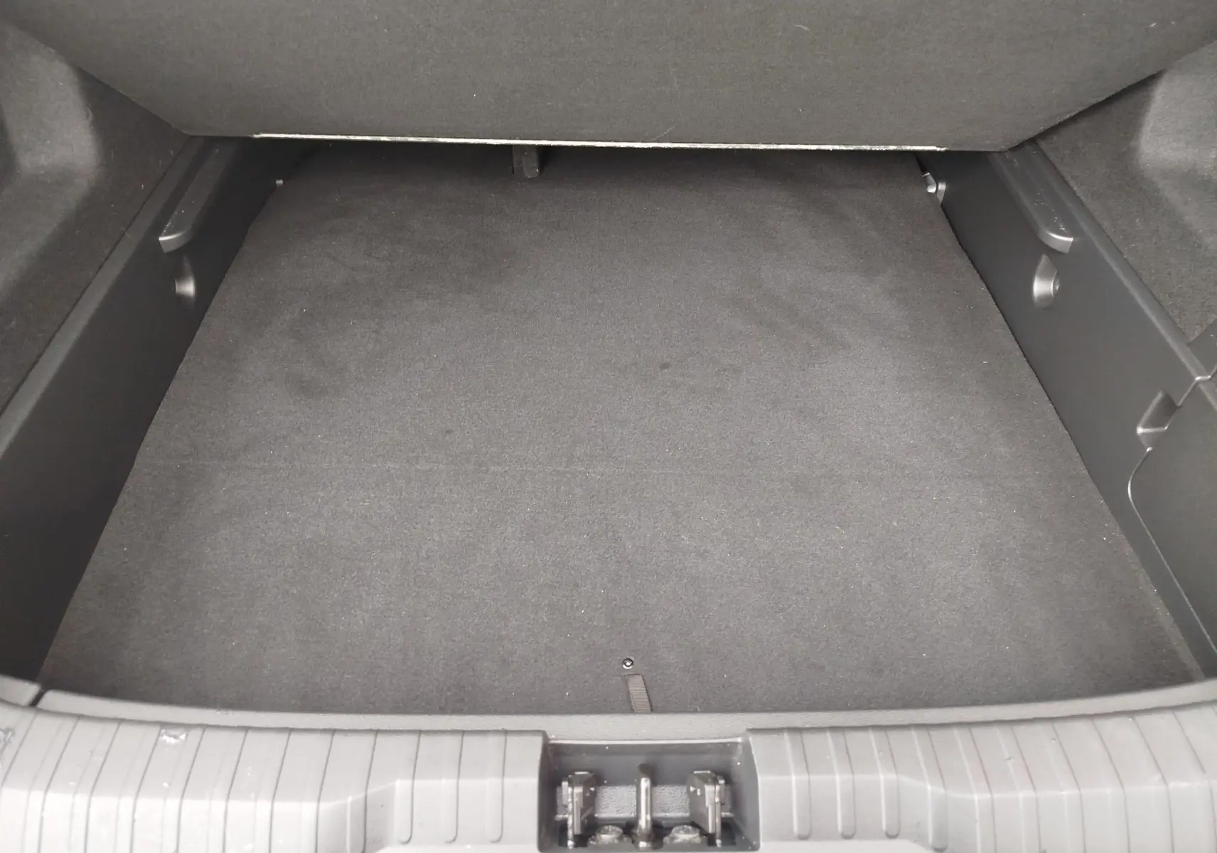 Coffre vide vu de face du Renault Arkana 1.6 E-Tech bleu Zanzibar, intérieur noir avec tapis de sol.