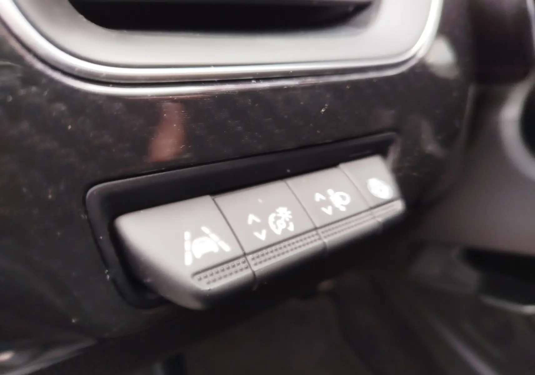 Gros plan sur les boutons de contrôle d’assistance à la conduite du tableau de bord d’un Renault Arkana bleu Zanzibar.