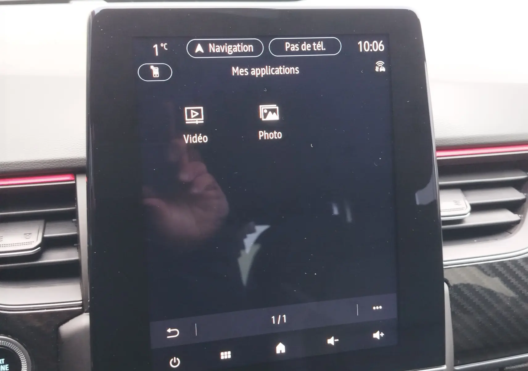 Écran tactile central de la Renault Arkana 1.6 E-Tech 2022 affichant les applications vidéo et photo, entouré de la console noire.
