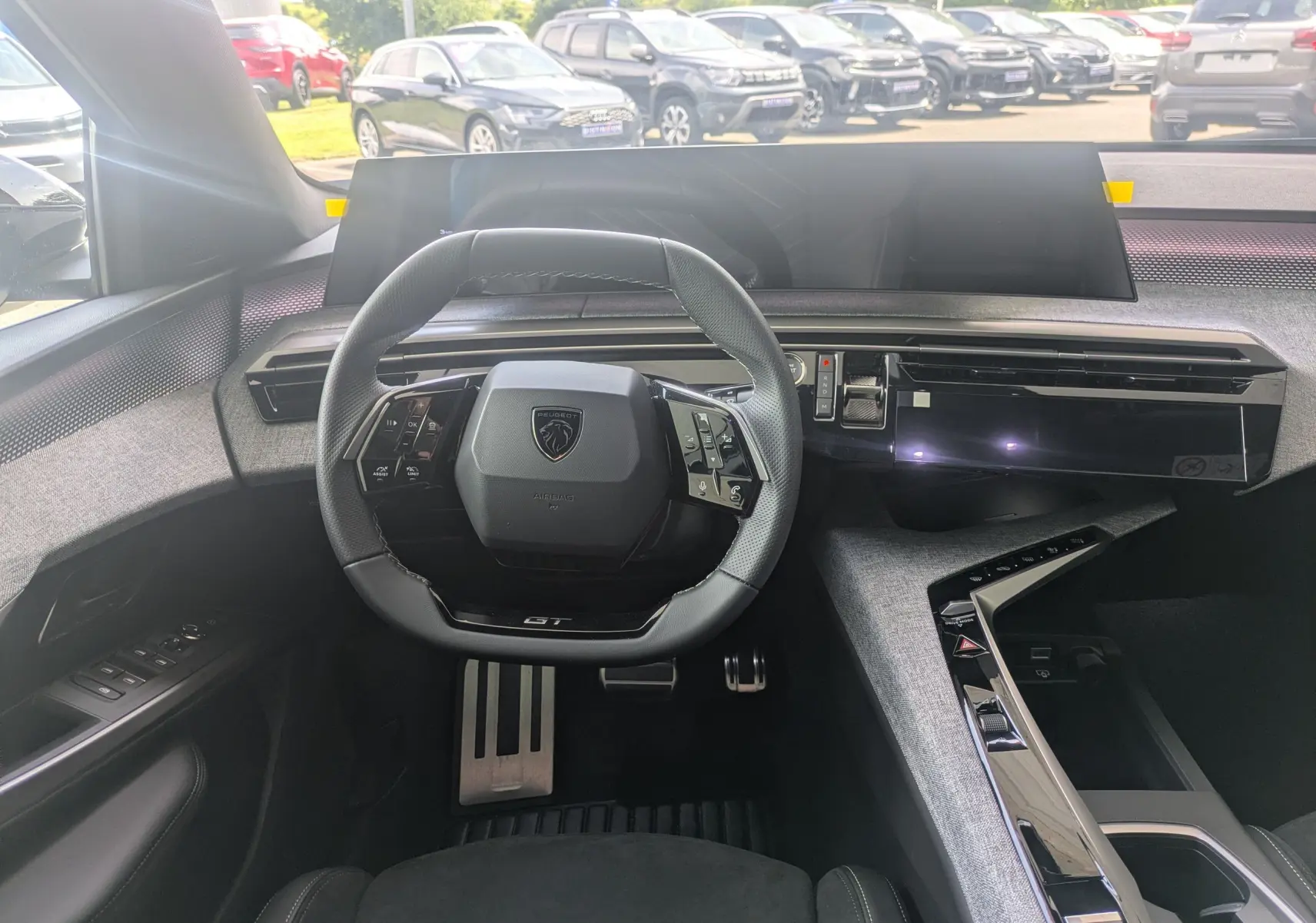 Vue intérieure centrée sur le volant GT et le tableau de bord numérique du Peugeot 3008 Hybrid 2026.