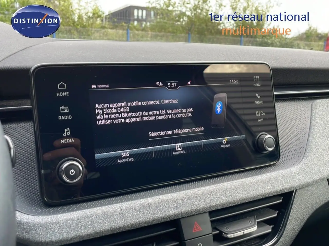 Écran tactile central de la Skoda Scala blanc glacier, affichant le menu Bluetooth avec commandes autour.