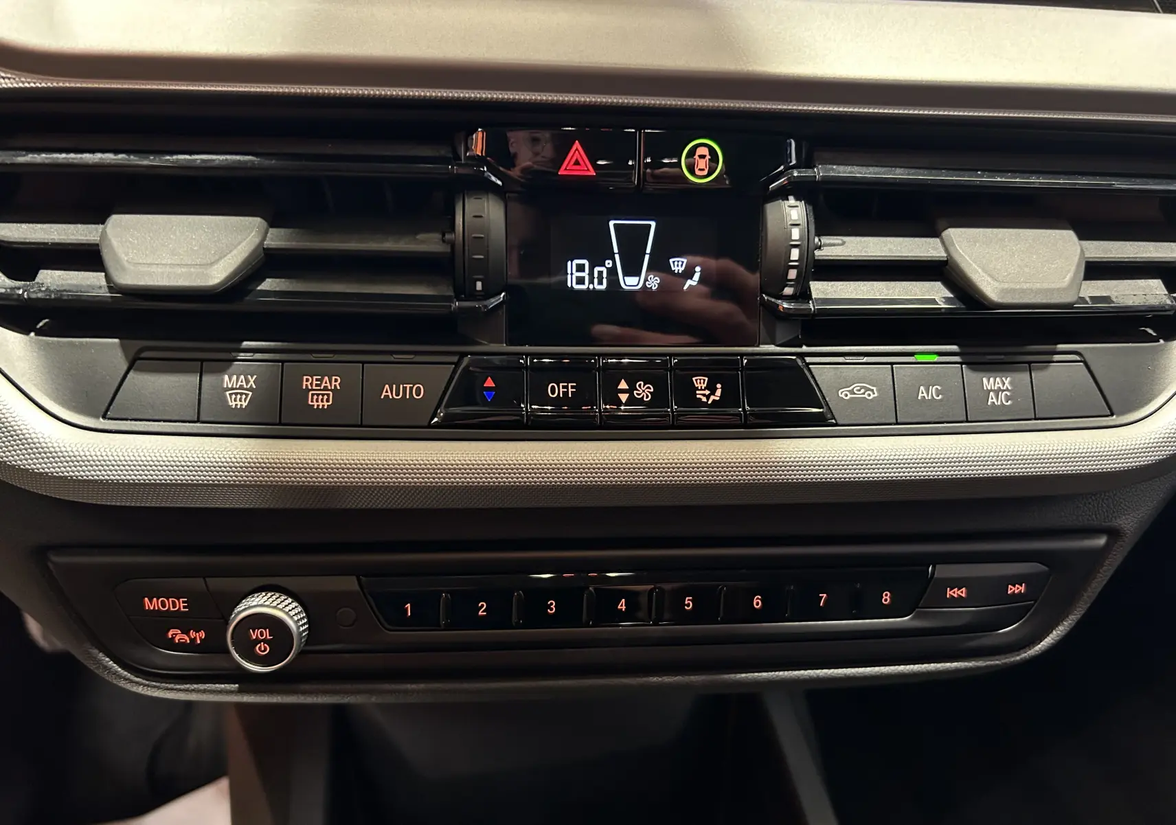 Tableau de bord de BMW Série 1 16d 2023 en noir, avec commandes climatisation digitale et réglages audio visibles.