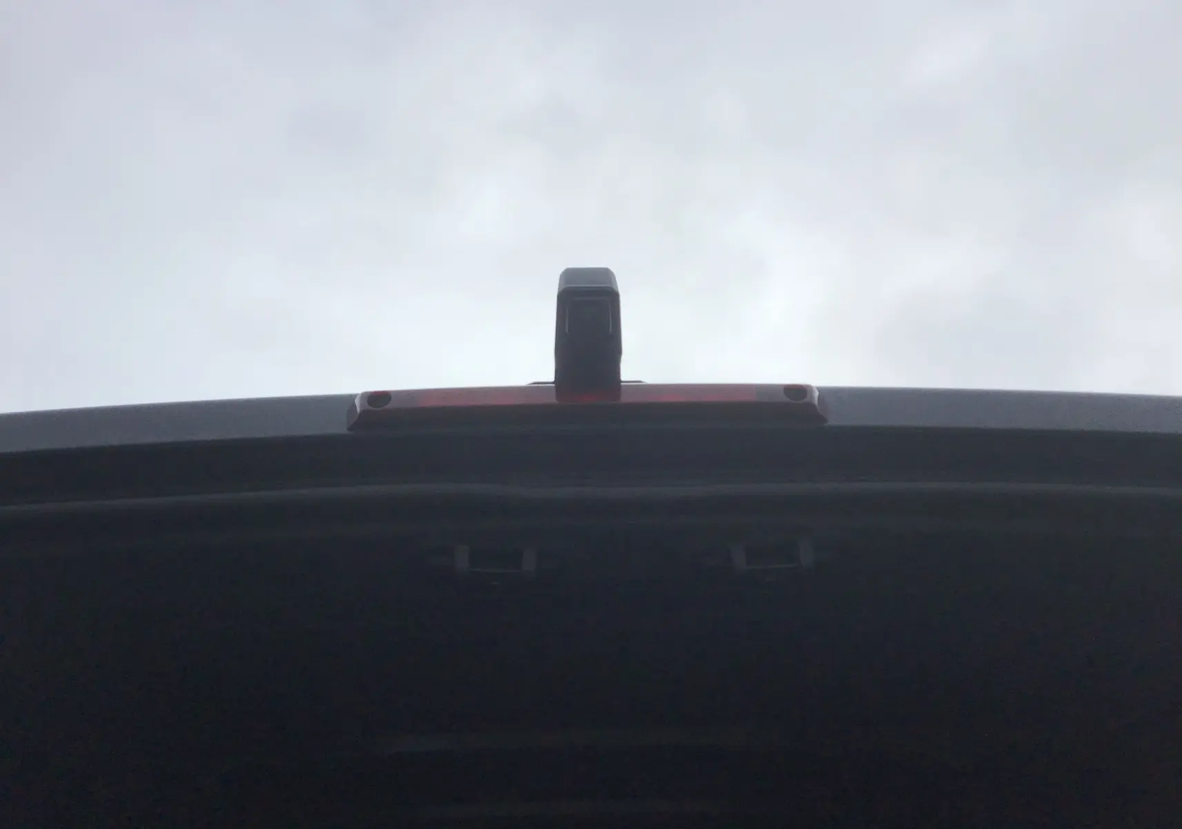 Vue en gros plan sur la caméra de recul installée sur la porte arrière ouverte du Renault Master gris urbain.