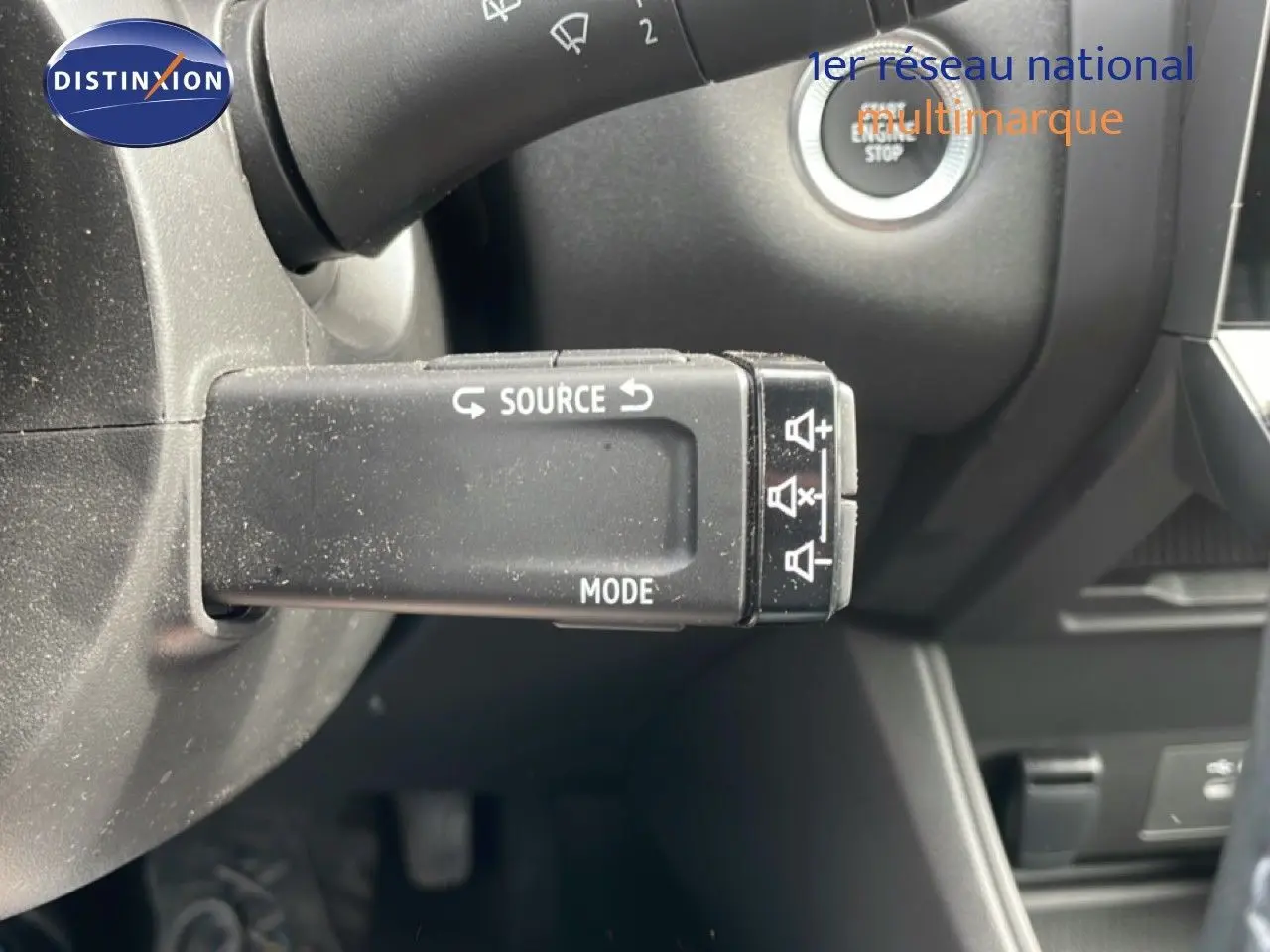 Gros plan sur la commande multimédia au volant du Renault Captur 2025 gris cassiopée métal avec toit noir.