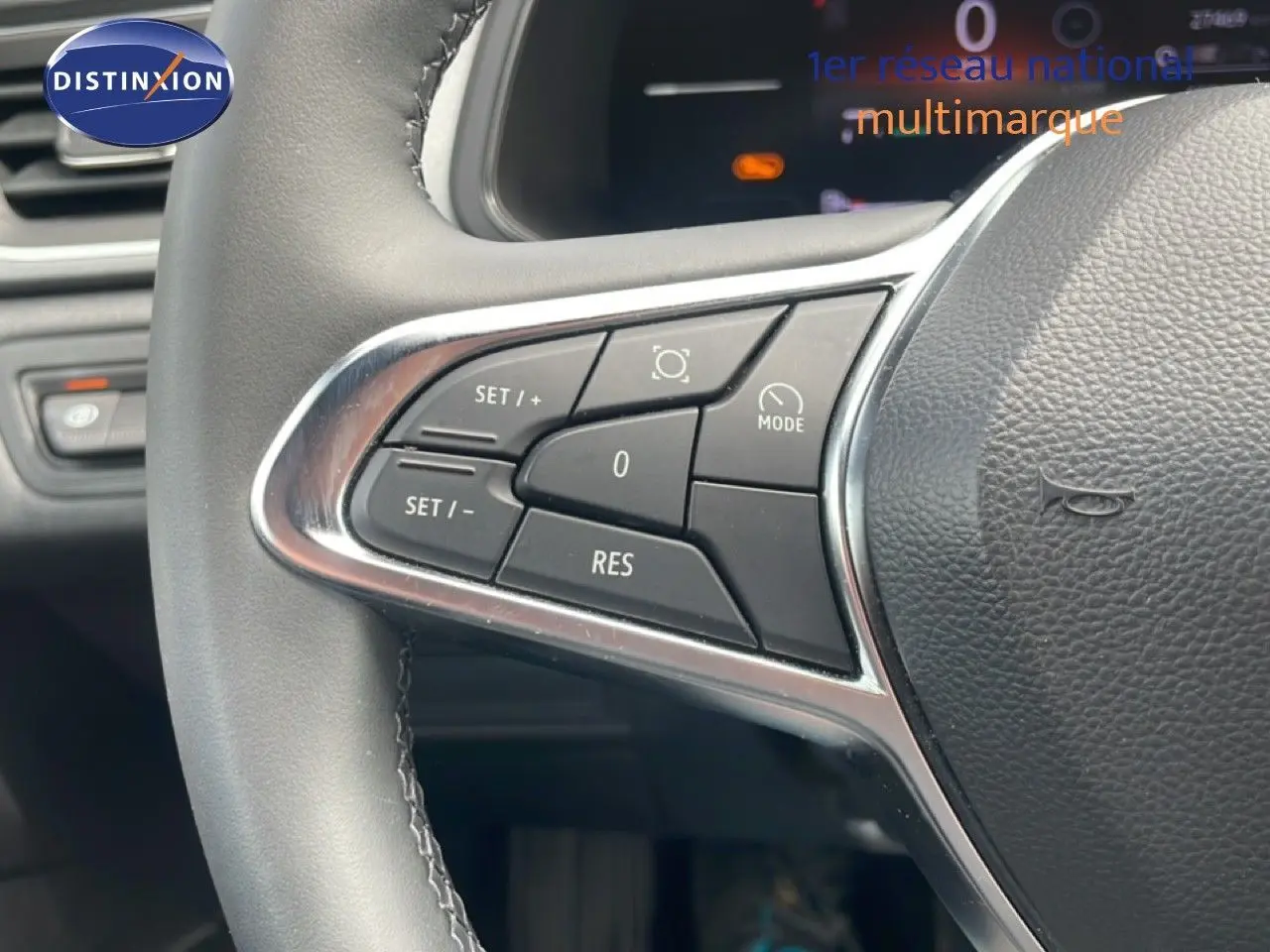 Gros plan sur les commandes au volant à gauche du Renault Captur 2025, volant cuir avec boutons de régulateur de vitesse.