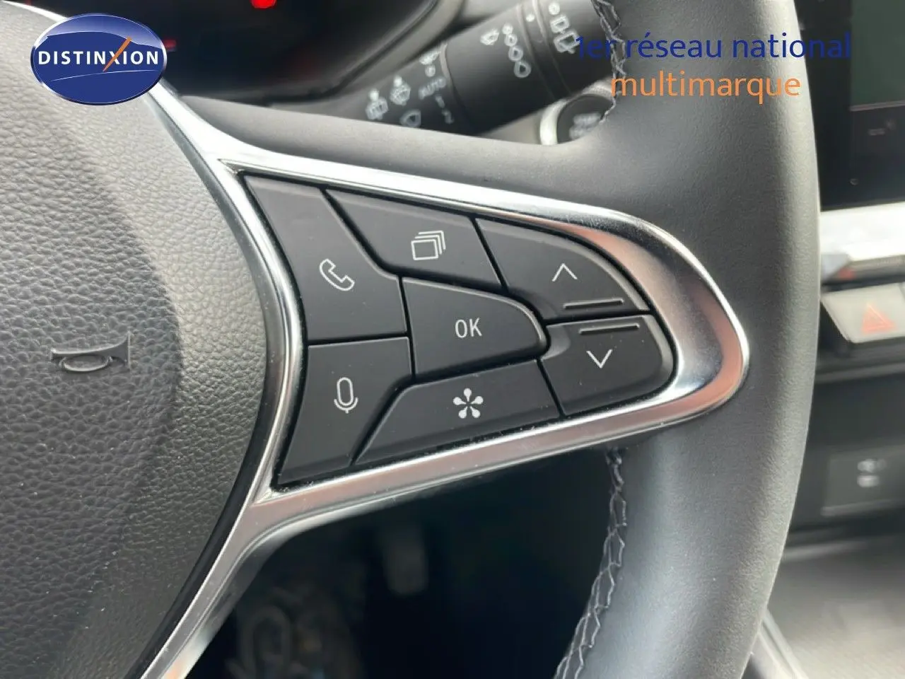 Gros plan sur les commandes multifonctions à droite du volant cuir noir du Renault Captur gris cassiopée métal.