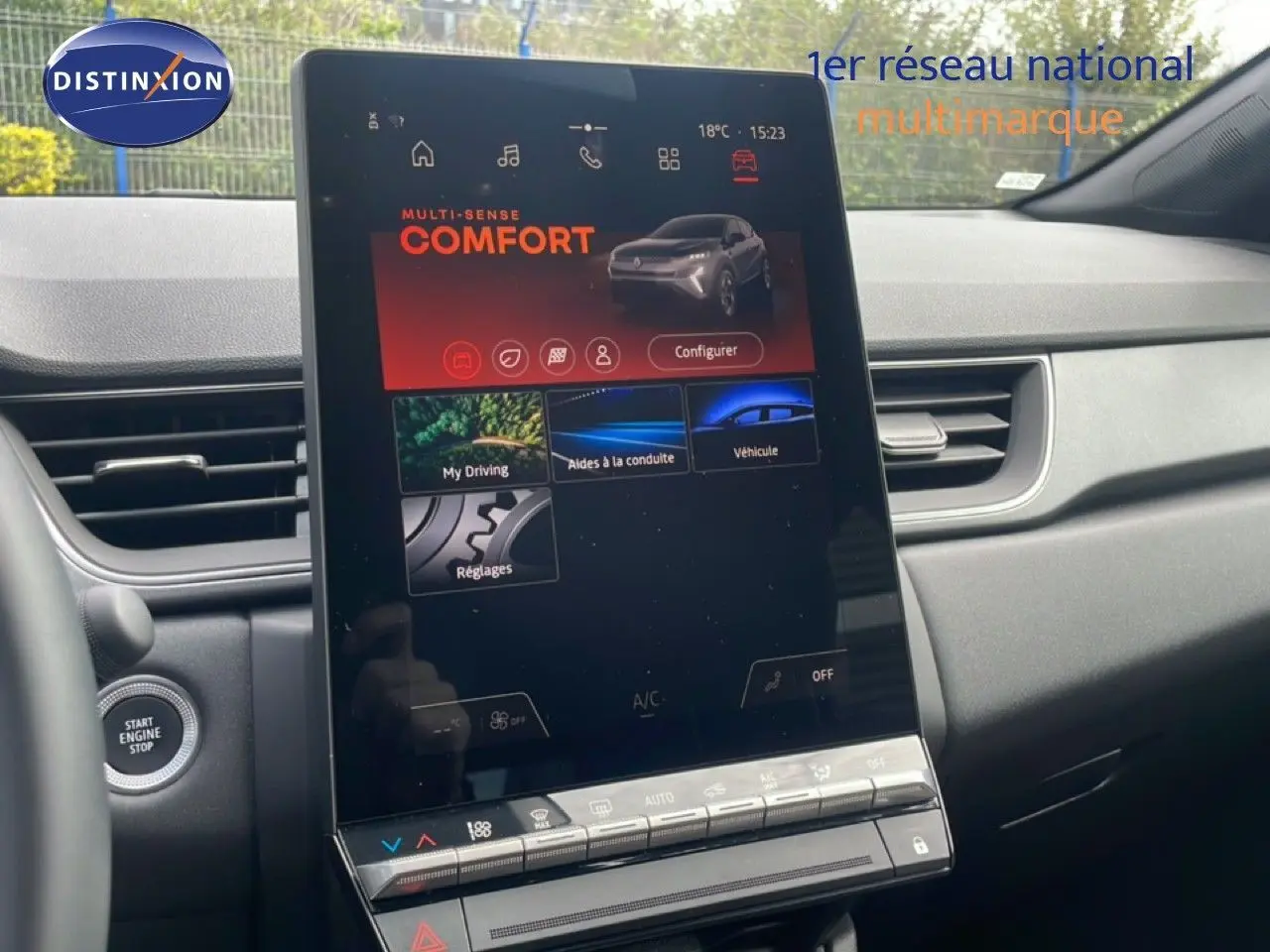 Vue intérieure centrée sur l'écran tactile vertical du tableau de bord du Renault Captur gris cassiopée métal avec toit noir.