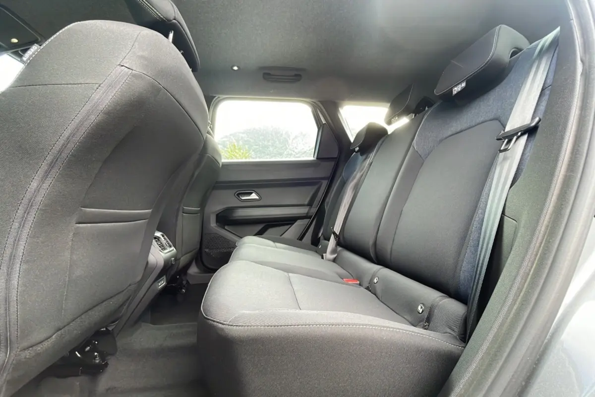 Vue latérale intérieure sur la banquette arrière grise du Dacia Bigster 2025, avec appuie-têtes et ceintures visibles.