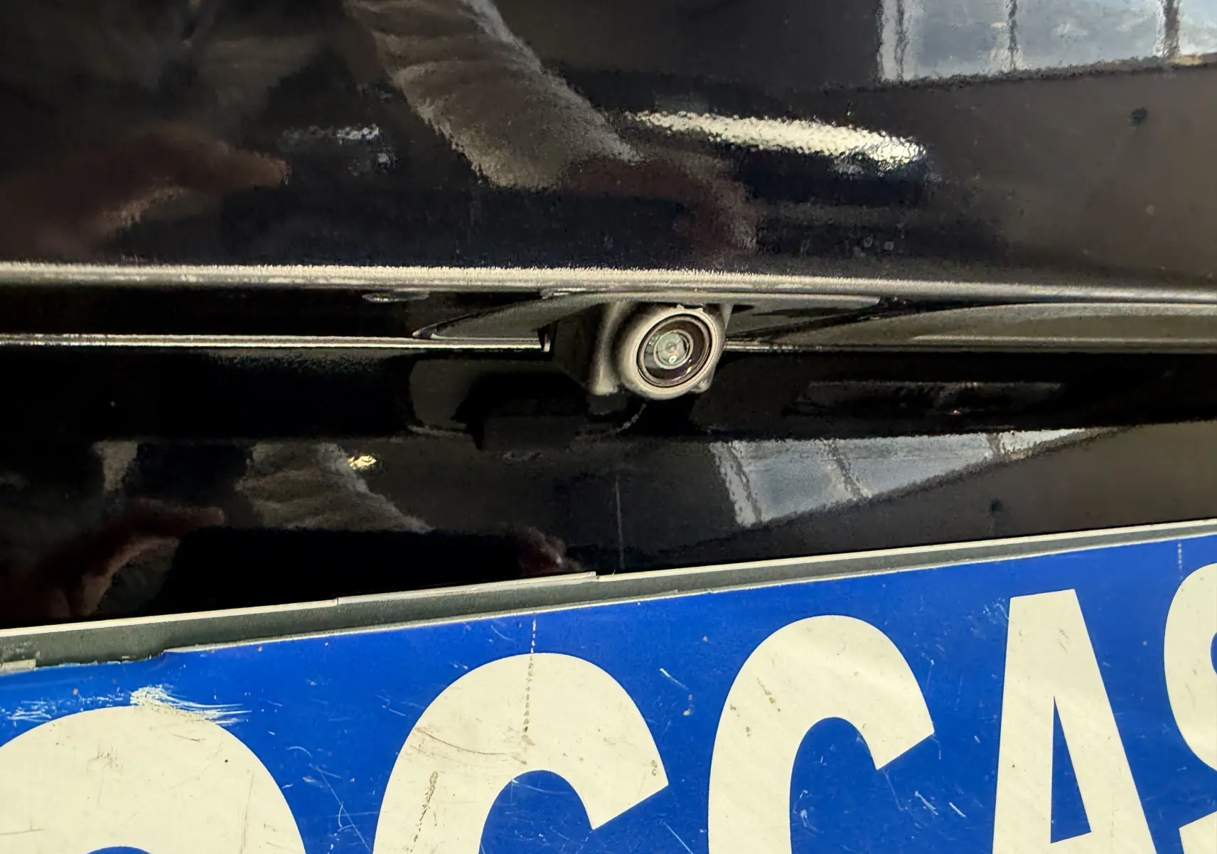 Gros plan sur la caméra de recul intégrée au-dessus de la plaque arrière d'une Opel Insignia Sports Tourer bleu lune marine.