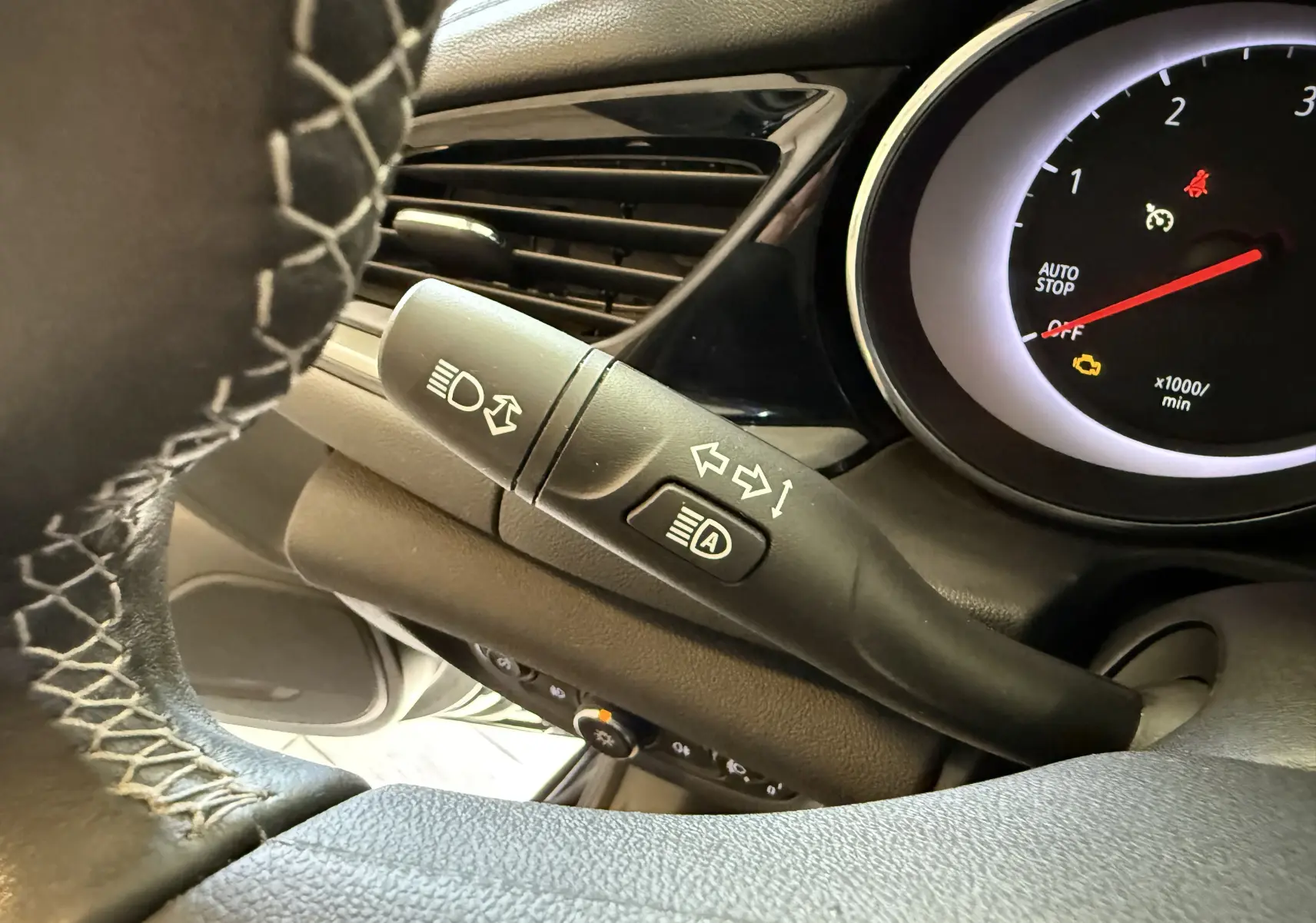 Gros plan sur la commande de clignotants et feux automatiques à gauche du volant d'une Opel Insignia Sports Tourer 2019.